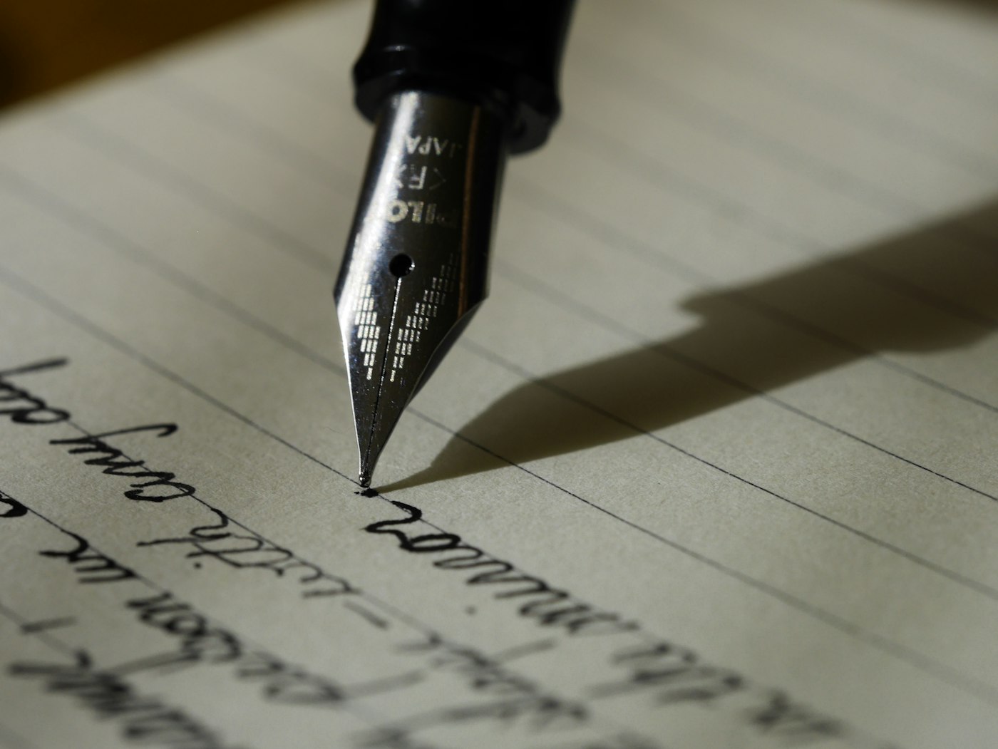 Notebook, handwritten notes, coffee, and writing materials on a desk